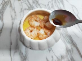 蒸好的虾仁蛋羹取出后淋上少许生抽，再滴入芝麻油。