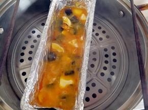皮蛋和咸鸭蛋倒进模具里，上面倒入蛋黄液，轻轻晃动模具，蒸锅上汽，上面放两根筷子，盖上锅盖蒸五分钟左右