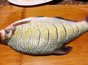 鱼洗净用刀在鱼身两面上划成如图的切口。