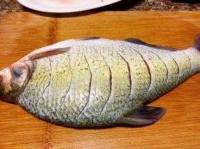 鱼洗净用刀在鱼身两面上划成如图的切口。