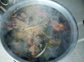 煤球烧旺后，把腌制好的牛肉带调料一起放炖锅，加上足够的清水，慢慢炖