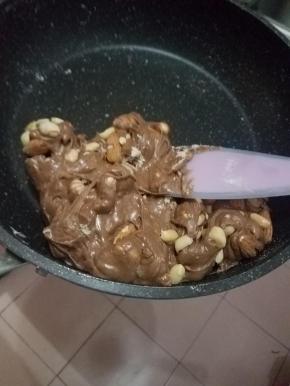 翻拌均匀后加入花生碎跟大杏仁，速度拌匀。