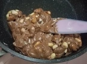 翻拌均匀后加入花生碎跟大杏仁，速度拌匀。