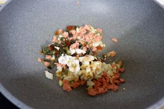 然后下入咸鸭蛋、皮蛋、火腿肠翻炒片刻