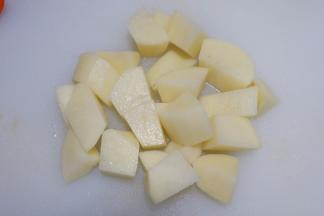 牛腩快闷好的时候，我们来处理蔬菜。土豆去皮洗净，切成滚刀块。