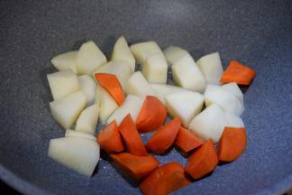 另起一个锅，加适量油，放入土豆和胡萝卜