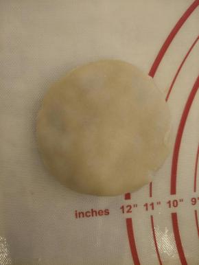 把面团擀成圆形，包住奶黄馅儿，按成圆饼