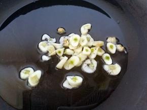 锅里的余油中放入大蒜片，爆香