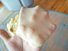 面包机工作到28分钟后，按暂时键，把面团取出来，这时候的面团，可以轻易拉出坚韧而薄的膜