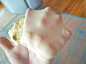 面包机工作到28分钟后，按暂时键，把面团取出来，这时候的面团，可以轻易拉出坚韧而薄的膜