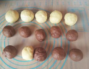 先把两种颜色的面团各切出30克（做两个猫咪用），然后白色的面团分成5份，可可面团分成8份，搓圆