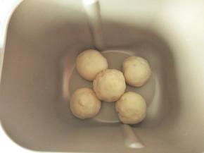 先把四个白色的小面团摆在面包机四个角，中间再放一个，如图排列