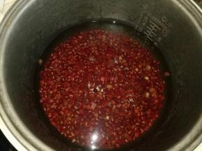 红豆捞出放电饭锅里，倒1500克清水，按下煮饭键，煮至软烂