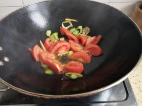热锅入油加入作料炒香再加入西红柿