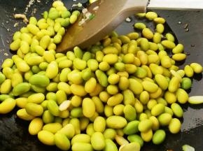 利用锅里的余油，倒入毛豆，加一点点水，翻炒一分钟左右