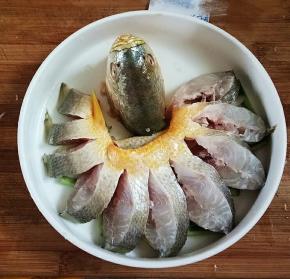把鱼盘入，淋上料酒，放入已开的锅中蒸7分钟。