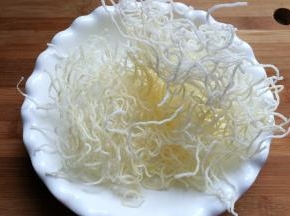 快速将炸好的粉丝捞起控油装盘备用