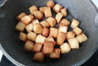 糖水煮至浓稠微黄时下入馒头丁翻拌均匀，使馒头丁均匀裹上糖浆后关火