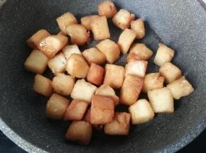 糖水煮至浓稠微黄时下入馒头丁翻拌均匀，使馒头丁均匀裹上糖浆后关火
