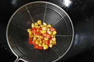 接着把玉米粒和红椒丁也下入油锅中过下油