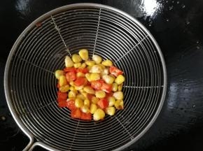 接着把玉米粒和红椒丁也下入油锅中过下油