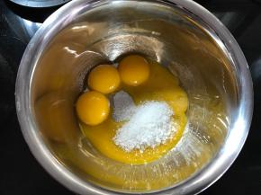 蛋黄中加入20克糖，用打蛋器打散。