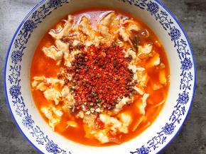 将花椒和辣椒面铺在表面。