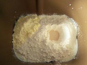倒入高筋面粉，奶粉，面粉中间挖个眼，倒入酵母