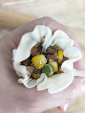 用左手虎口收起来，右手大拇指把馅往中间挤一下，虎口继续收紧，掐出腰身哈哈( •̀∀•́ )