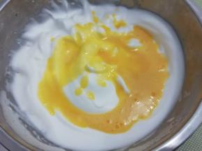 在把打好的蛋黄糊倒入蛋白中