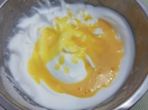 在把打好的蛋黄糊倒入蛋白中