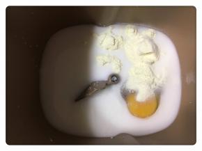 将材料里的水、牛奶、鸡蛋、蜂蜜、奶粉、细砂糖放入面包桶中。