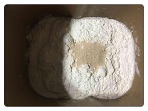 放入高粉、低粉和酵母，酵母放中间。然后开始设置揉面功能。
