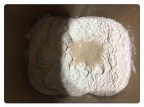 放入高粉、低粉和酵母，酵母放中间。然后开始设置揉面功能。
