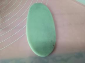 用擀面杖从中间向两边推，擀成牛舌状，注意不要来回擀，以免破皮