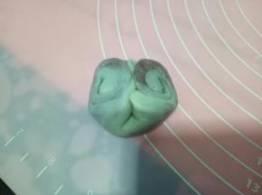 取一个卷卷，用食指在中间压一下，然后两边往上翻，像图中这样