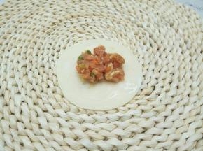 取饺子皮一张，中间放上肉馅，饺子皮四周抹上水