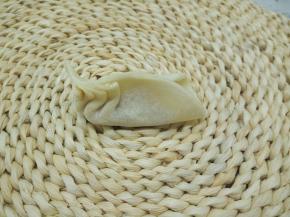 饺子皮对折捏紧，一边往中间捏褶，