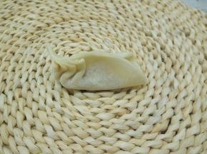 饺子皮对折捏紧，一边往中间捏褶，