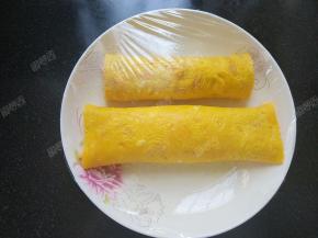 将卷好的蛋卷放入刷过油的平盘中，盖上保鲜膜