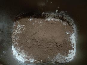 对角放细砂糖和盐，再加入高筋面粉、全麦粉和可可粉。