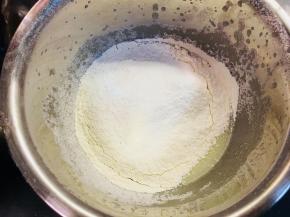 待表面没有油花，容器中液体略显浓稠后，完成乳化，筛入低粉与玉米淀粉。这里请将低粉和玉米淀粉事先混合。