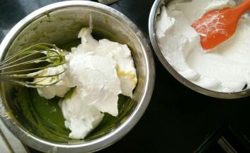 取三分之一蛋白糊加入蛋黄糊里，翻拌均。同时预热烤箱。