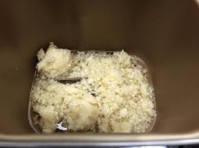 把挤干水分的蒜末倒入面包机桶内