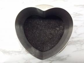 处理好的饼干碎倒入模具中，竖起擀面杖将饼干碎压紧压实。之后放入冰箱冷冻备用。