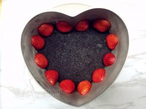 贴面用的草莓稍微切去蒂部，使之平整，再对半切开。将切面紧贴着模具，围上一圈。