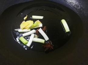 素鸡泡好后，热锅放油烧至八分热，加入葱姜和八角，在油锅里爆香