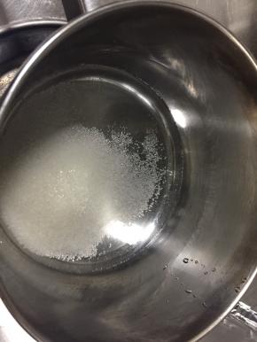 准备小奶锅，锅中倒入清水和白砂糖，另清水盖过砂糖，开火煮沸至砂糖煮化