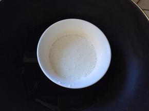 趁发酵的时间来做麻薯，将除黄油以外的东西全部放入碗里，搅拌均匀，放入锅里中火蒸10分钟