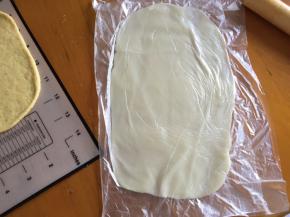 拿出一个面团擀成长方形，将麻薯放入保鲜袋也擀成长方形